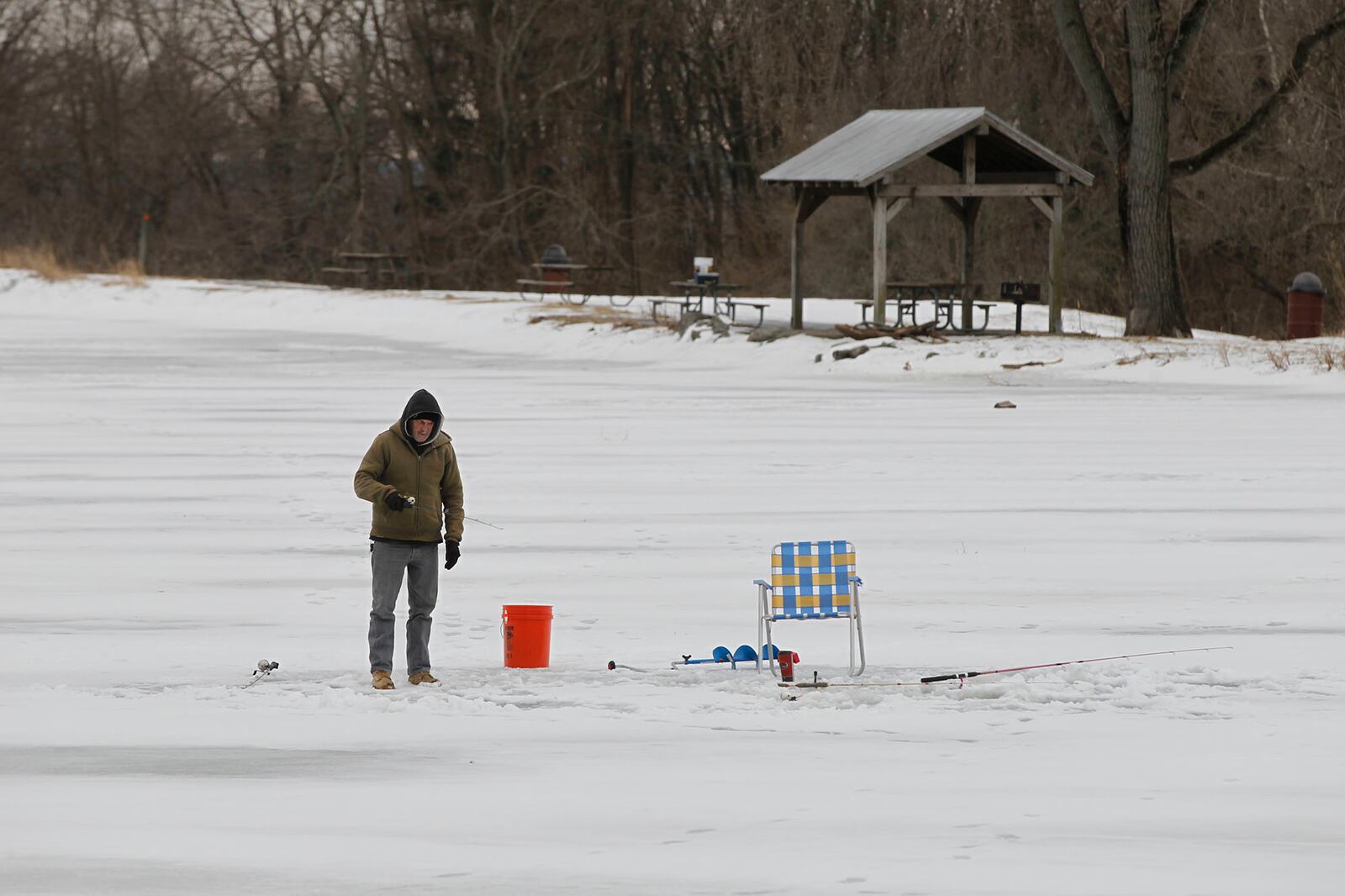 Possum Creek Metropark was a popular spot for ice fishing on Saturday. The lakes were stocked with rainbow trout in January and anglers cut holes through ice varying from six to 11 inches thick. Greg Orona, Sr. drove from Franklin to try for trout. TY GREENLEES / STAFF