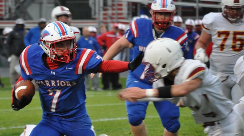 Northwestern junior Eli Berner throws a stiff arm en route to a 9-yard scoring run during the Warriors’ first touchdown of the game Friday night, Sept. 1.