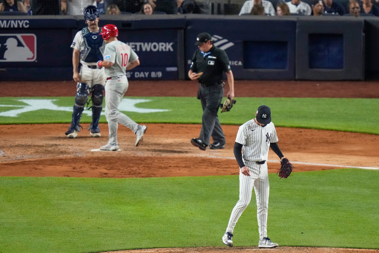 New York Yankees pitcher Luke Weaver, right, looks down as Philadelphia Phillies' J.T. Realmuto reaches home plate after hitting a three-run home run during the seventh inning of a baseball game Friday, July 25, 2025, in New York. (AP Photo/Frank Franklin II)