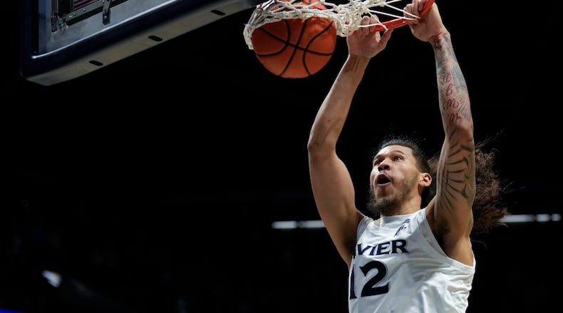 Xavier forward Tre Carroll (12) dunks the ball during the fist half of an NCAA college basketball game against UConn, Wednesday, Dec. 31, 2025, in Cincinnati. (AP Photo/Carolyn Kaster)