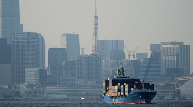 FILE -Tokyo Tower is seen amid tall buildings as a container ship leaves a cargo terminal in Tokyo, Wednesday, April 9, 2025. (AP Photo/Hiro Komae, File)