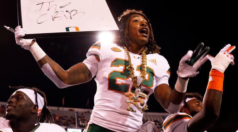 CHARLOTTESVILLE, VA - OCTOBER 13: Sheldrick Redwine #22 of the Miami Hurricanes celebrates with the turnover chain in the first half during a game against the Virginia Cavaliers at Scott Stadium on October 13, 2018 in Charlottesville, Virginia. (Photo by Ryan M. Kelly/Getty Images)
