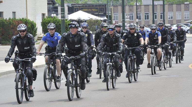 Dayton police ride bikes alongside protesters on Wayne Ave. Saturday to protect them as they march for George Floyd. MARSHALL GORBYSTAFF