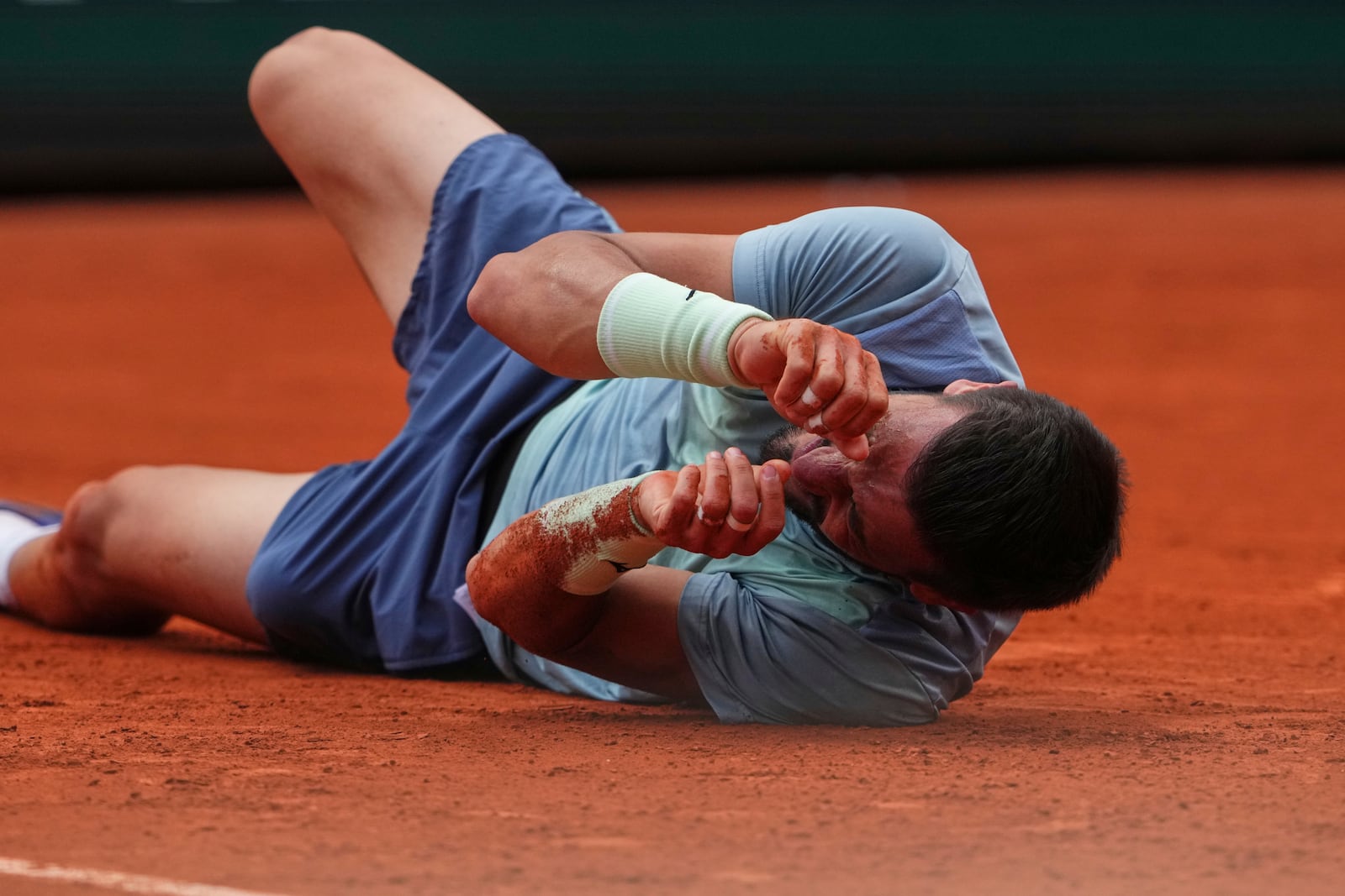 Bosnia and Herzegovina's Damir Dzumhur grimaces in pain after falling during his second round match of the French Tennis Open against France's Giovanni Mpetshi Perricard, at the Roland-Garros stadium, in Paris, Wednesday, May 28, 2025. (AP Photo/Lindsey Wasson)