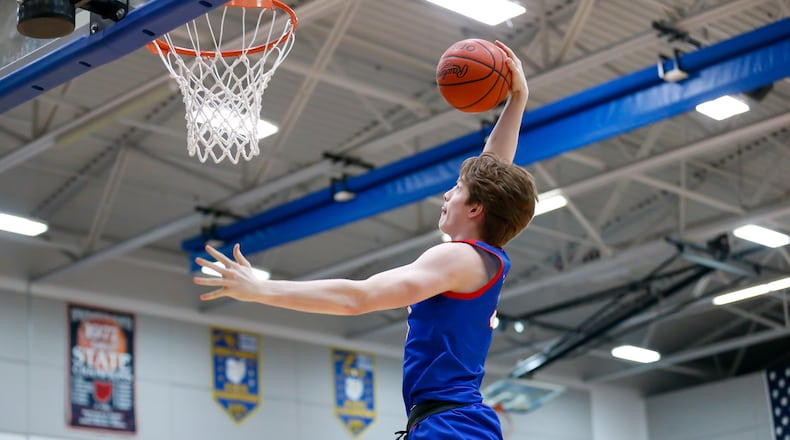 Carroll High School junior Tanner Smart leaps for a dunk during their Division II district semifinal game against Trotwood-Madison on Friday night at Springfield High School. CONTRIBUTED PHOTO BY MICHAEL COOPER