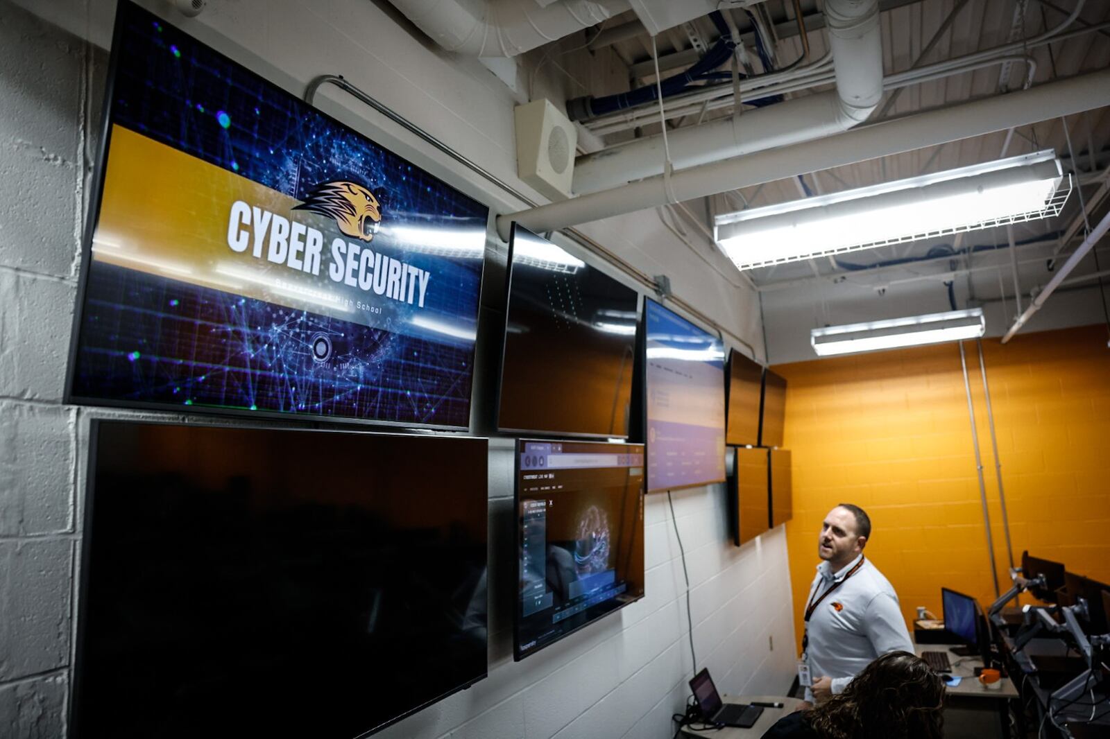 Beavercreek High School curriculum supervisor Josh Baker checks-out newly installed large screens for the school's new computer science career tech classroom. JIM NOELKER/STAFF