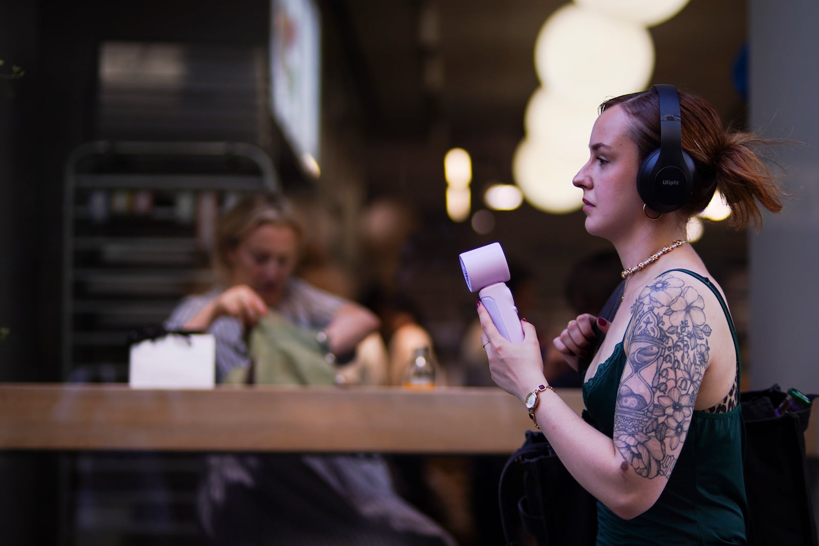 A woman uses a handheld fan in hot weather in Covent Garden, in London, Monday, June 30, 2025. (AP Photo/Alberto Pezzali)