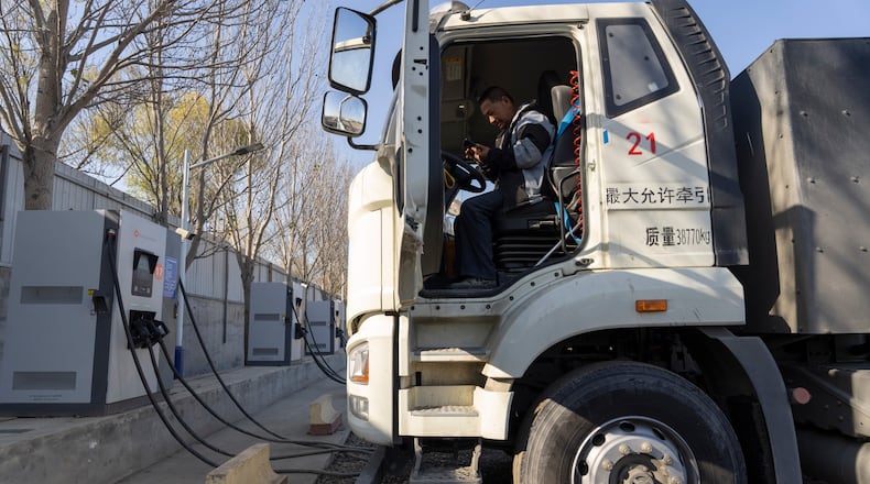 A driver sits in his electric truck at a charging station on the outskirts of Beijing, on Nov. 14, 2025. (AP Photo/Ng Han Guan)