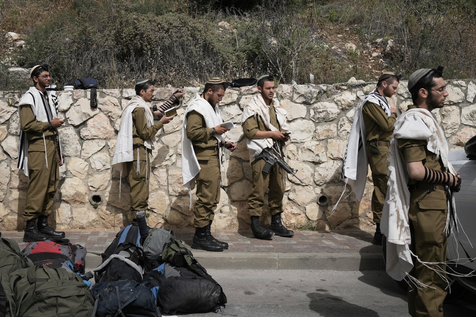 Israeli soldiers have their morning prayer ahead of two minutes of silence, as air raid sirens sound marking the Israel's annual Memorial Day for the fallen soldiers and victims of nationalistic attacks at Mount Herzl military cemetery in Jerusalem, Wednesday, April 30, 2025. (AP Photo/Maya Alleruzzo)