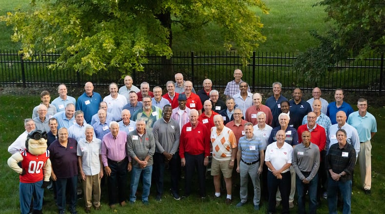 Former Dayton coach Don Donoher, center in red, poses for a photo with his former players at a reunion on Oct. 9, 2021, in Dayton.Pictured are: ROW 1: Rudy Flyer; Bobby Hooper; Joe Emmrich; Jim Larkin; Rex Gardecki; Anthony Grant; Don Donoher; Chris Harris; John Cortney; Gary McCans; Russ Willis; and Paul Donoher.ROW 2: Jim Stiff; Dave Pressley; Dan Christie; Robert Urbanowicz; Dave Borchers; Tom Crosswhite; Roosevelt Chapman; Kevin Conrad; Greg Ellison; Al Bertke; Mike Byrd; and Damon Goodwin.
ROW 3: Dan Sadlier; George Janky; Mark Knue; Brian Donoher; Steve Hess; Pat Murnen; George Morrison; Gene Klaus; Doug Harris; Ken May; J.D. Grigsby; Mike Sylvester; and Ed Young.
ROW 4: Mike Kanieski; Bill Uhl; Tim Pohlman; Don May; John Samanich; Dan Herling; Steve Turnwald; Fred Eckert; Leighton Moulton; Jack Zimmerman; Nolan Robinson; and Bill Crotty. Photo courtesy of Natalie Schindler Photography