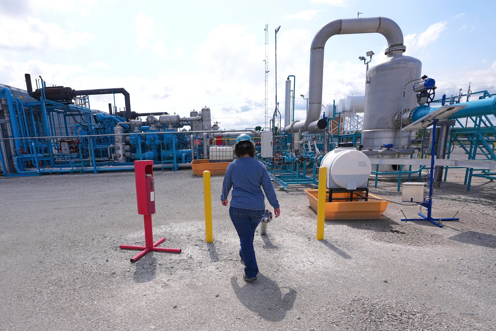 BKV Carbon Ventures senior facility engineer Laura Mamazza walks at a compression station at a carbon capture and sequestration facility in Bridgeport, Texas, Thursday, May 29, 2025. (AP Photo/LM Otero)