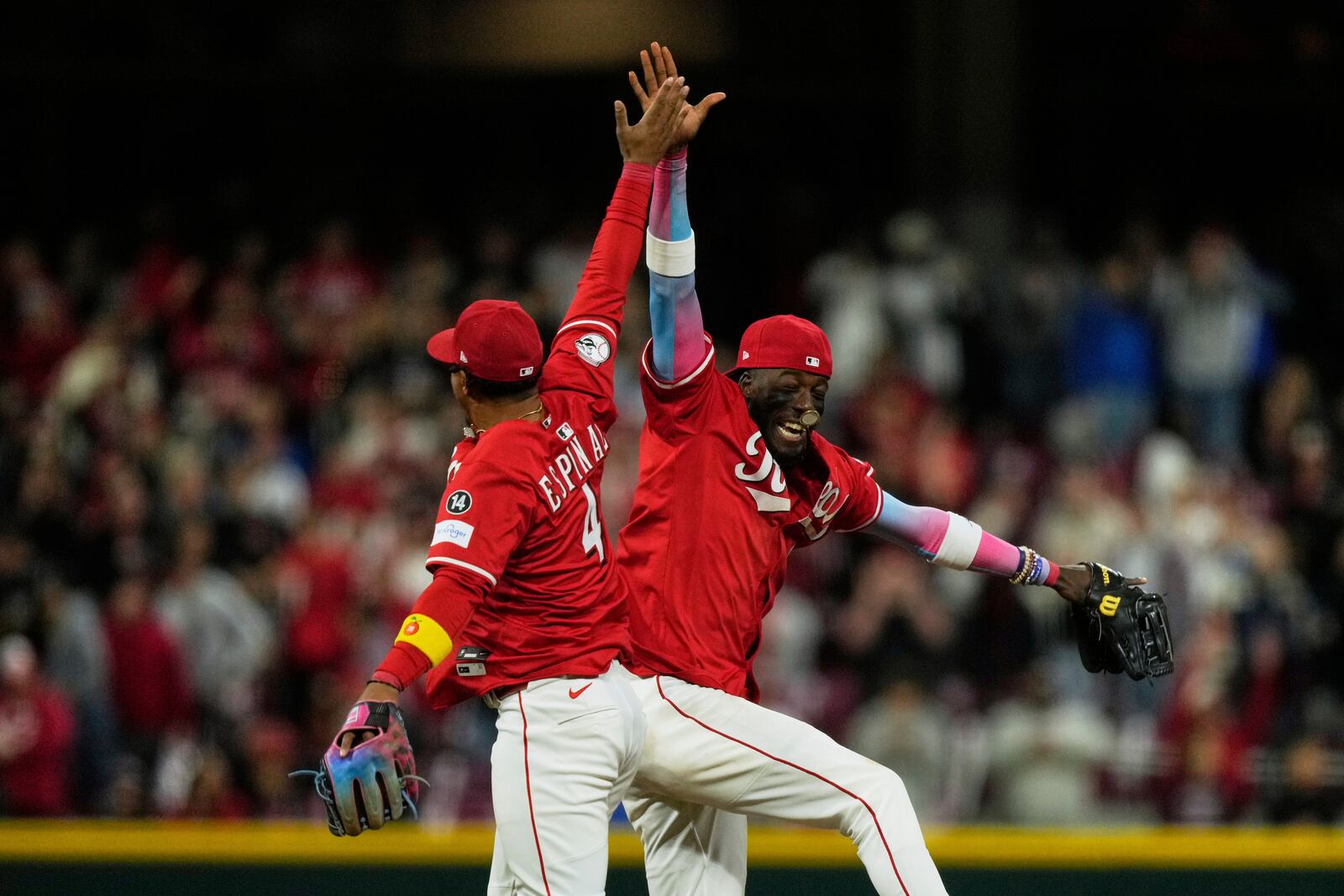 Cincinnati Reds shortstop Elly De La Cruz, right, and second baseman Santiago Espinal, left, celebrate winning a baseball game against the Pittsburgh Pirates, Saturday, April 12, 2025, in Cincinnati. (AP Photo/Carolyn Kaster)