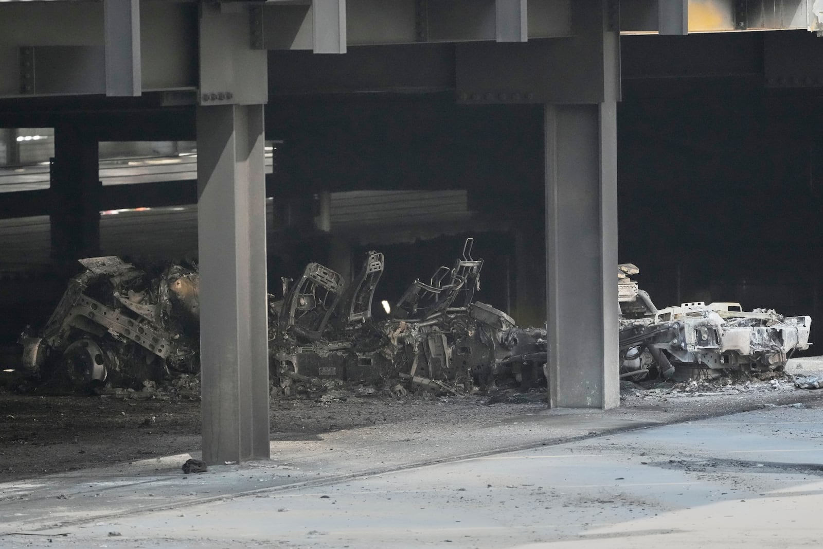 A burned vehicle is seen inside a garage that caught fire and a floor of the structure collapsed Tuesday, June 10, 2025, in Nashville, Tenn. (AP Photo/George Walker IV)