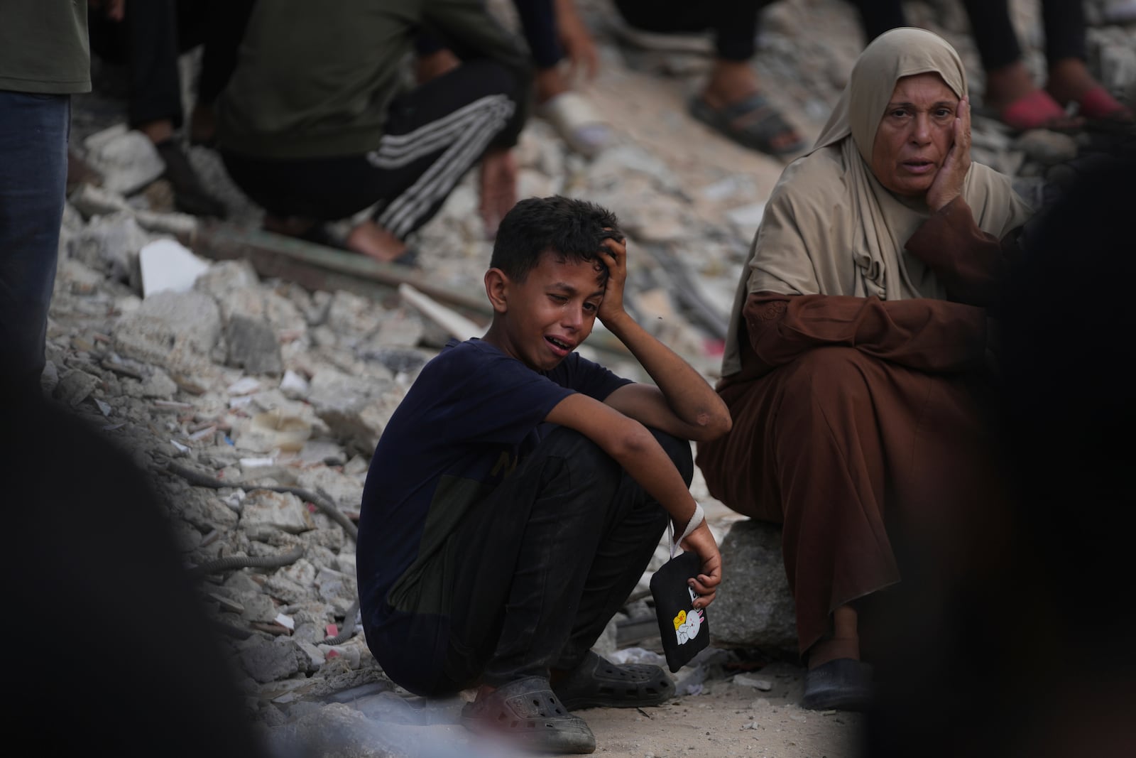 Palestinians mourn during the funeral of people who were killed while trying to reach aid trucks entering northern Gaza through the Zikim crossing with Israel, at Shifa Hospital, in Gaza City, Saturday, July 26, 2025. (AP Photo/Abdel Kareem Hana)