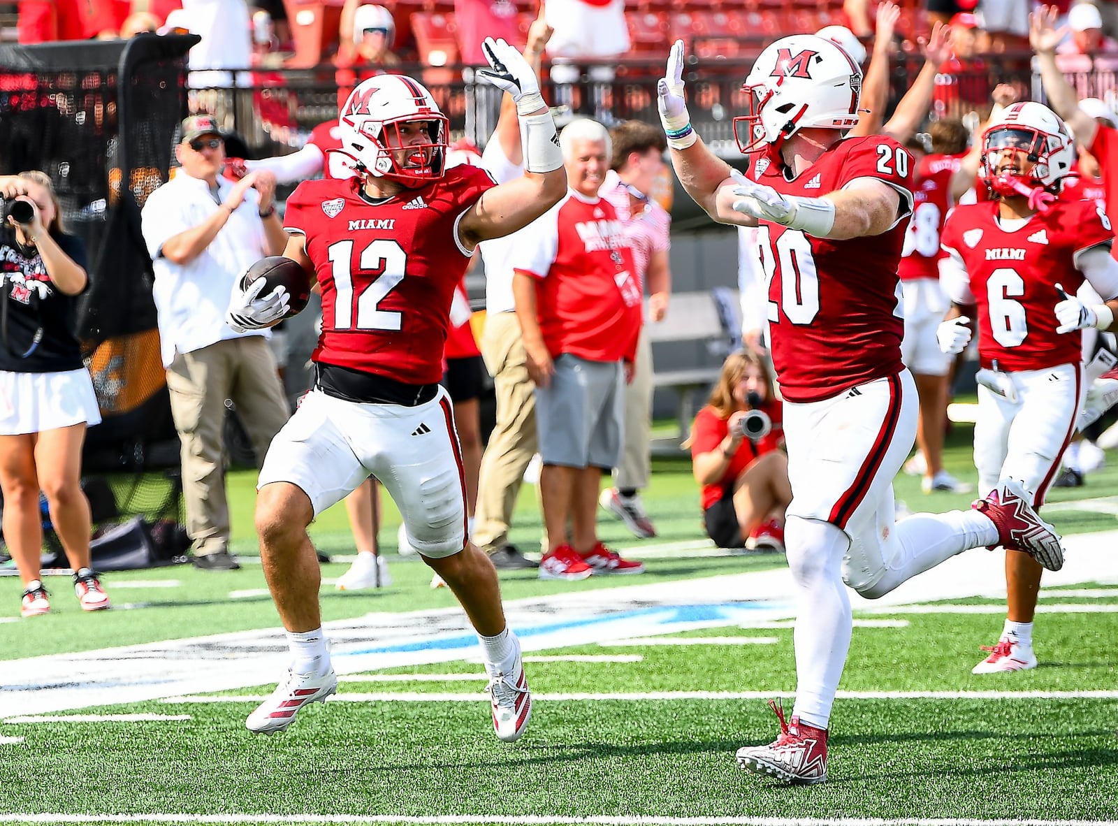 Miami's Corban Hondru high-fives teammate Adam Trick during an interception return that went for a score against UNLV last week at Yager Stadium. KYLE HENDRIX / CONTRIBUTED