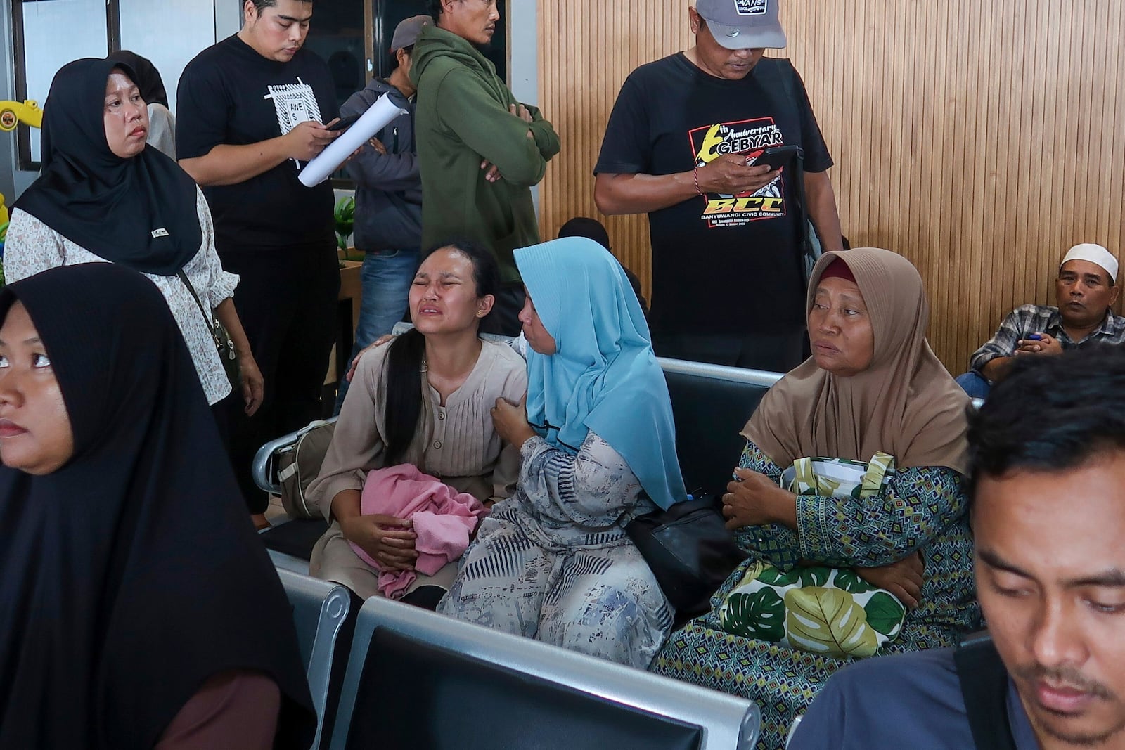 A passenger's relative weeps after a ferry carrying dozens of passengers sank near the resort island of Bali, at Ketapang Port in Bayuwangi, East Java, Indonesia, Thursday, July 3, 2025. (AP Photo/Andur)