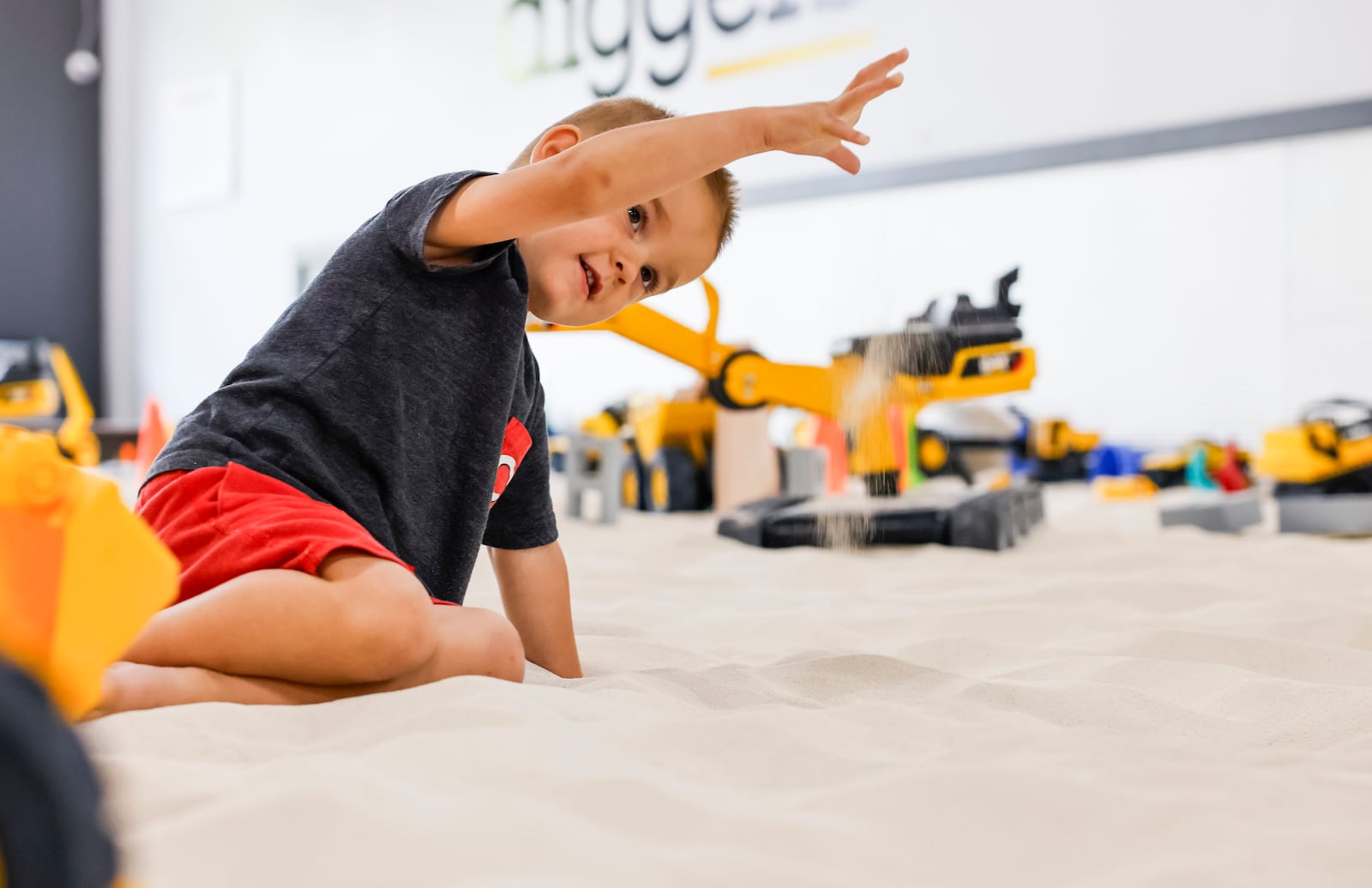 Tucker Canfield, 3, plays in the sand at Little Diggers play place for kids 7 and younger at 9442 Waterfront Drive in West Chester Township. There are toy excavators, dumps trucks and more to play with in the giant indoor sand box and two smaller sandboxes that can be used for private party events. NICK GRAHAM/STAFF