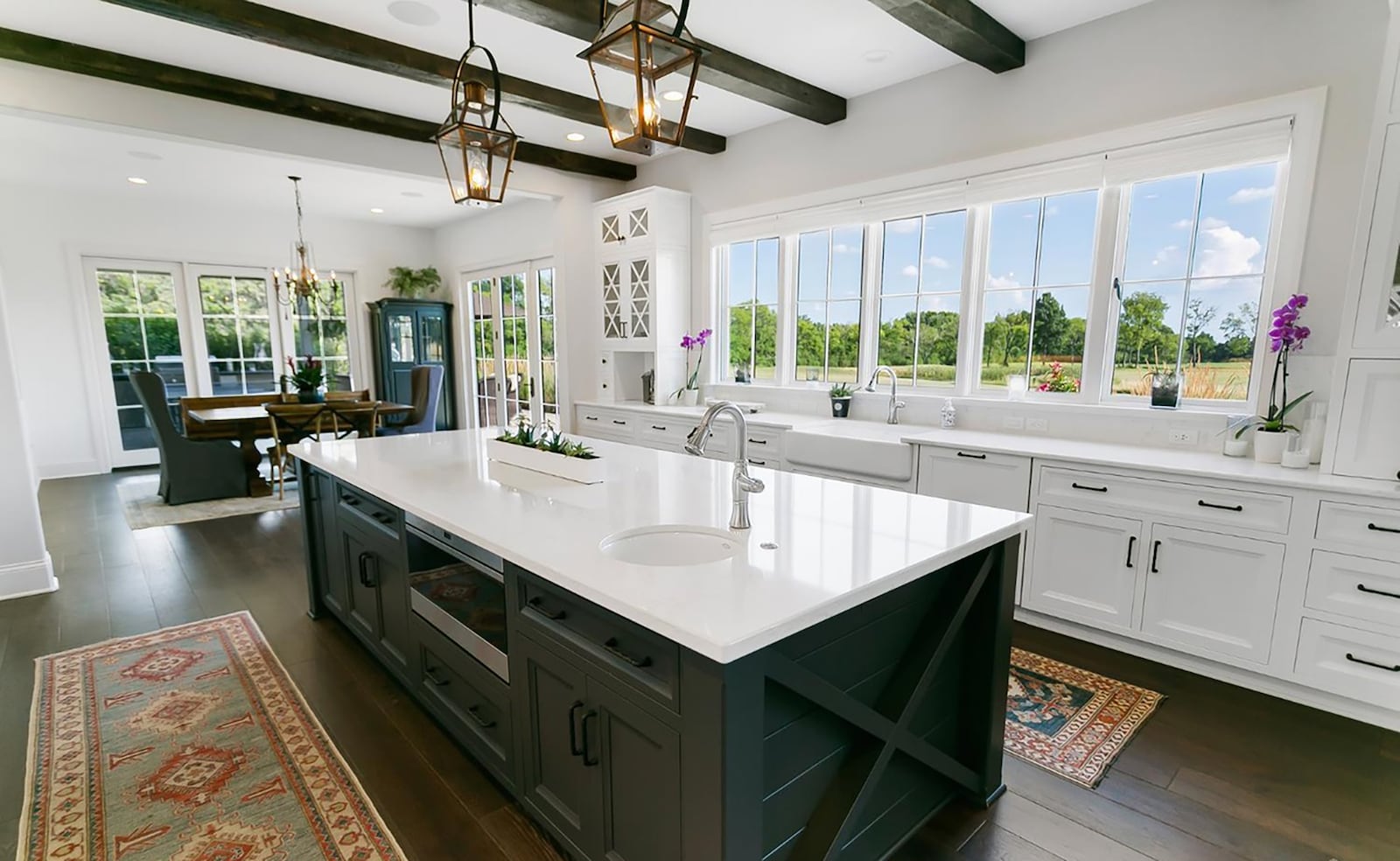 The gourmet kitchen features quartz countertops, wood floors and high end appliances. It also has a beamed ceiling and an island. CONTRIBUTED
