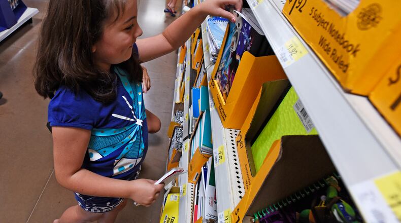 Gracie Reece, 7, shops for school supplies with her mom and grandma Thursday, July 30 at Walmart on Cincinnati-Dayton Road in West Chester Twp. NICK GRAHAM/STAFF