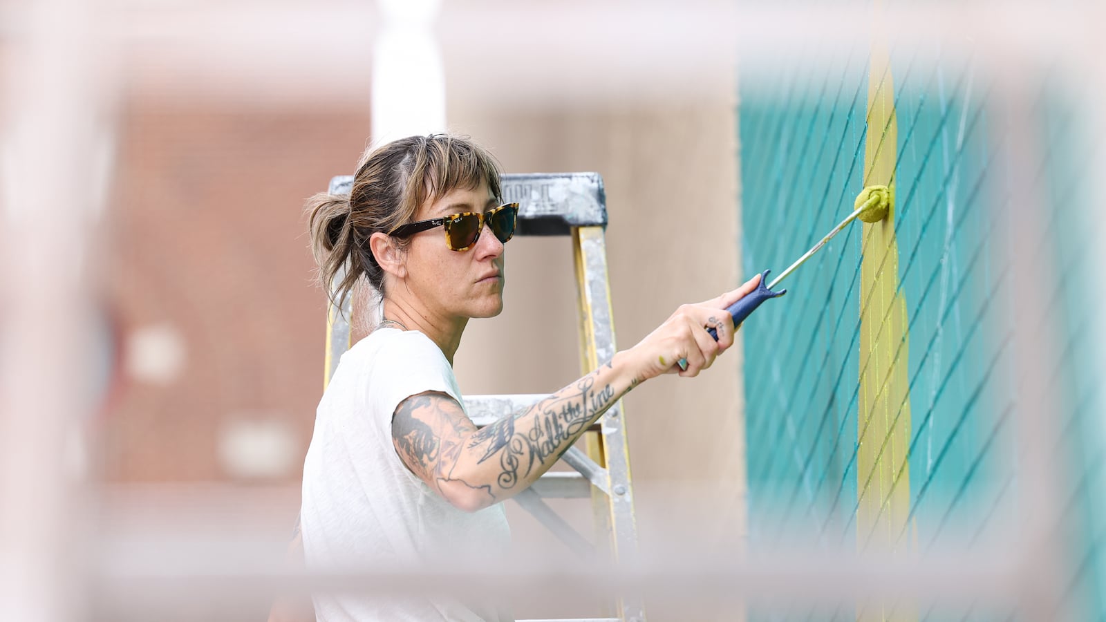 Maggie Leadman paints a part of mural on Courthouse Square on Wednesday, May 14. The mural was designed by Atalie Gagnet, who was also painting Wednesday and overseeing the project. Gagnet has designed many murals around Dayton. The one on the Courthouse Square was being prepared ahead of the NATO assembly on Memorial Day weekend. BRYANT BILLING / STAFF