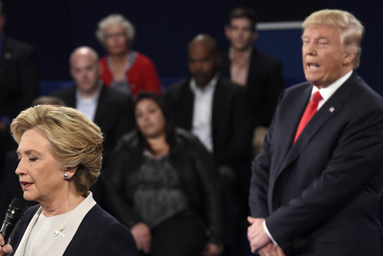 Democratic presidential nominee Hillary Clinton, left, talks as Republican presidential nominee Donald Trump watches her during the second presidential debate at Washington University in St. Louis, Sunday, Oct. 9, 2016. (Saul Loeb/Pool via AP)