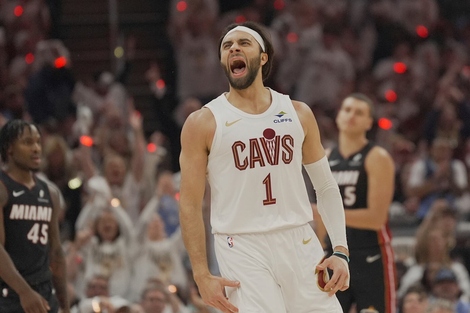 Cleveland Cavaliers guard Max Strus (1) shouts in front of Miami Heat guard Davion Mitchell (45) and forward Nikola Jovic (5) after hitting a three-point basket in the first half in Game 2 of an NBA first-round playoff series, Wednesday, April 23, 2025, in Cleveland. (AP Photo/Sue Ogrocki)