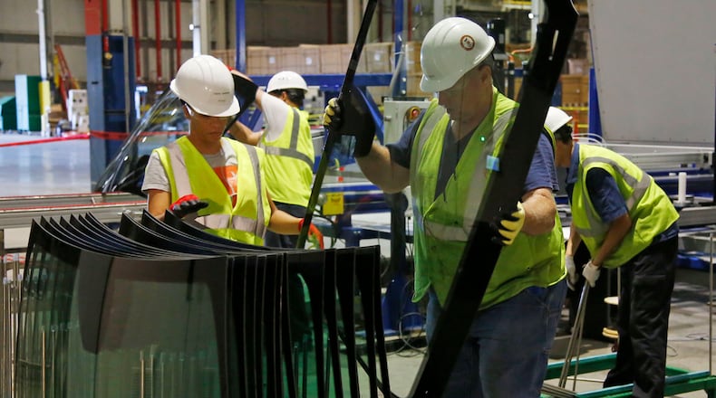 Workers in the Fuyao Glass America Moraine plant stack newly manufactured windshields in 2016. TY GREENLEES / STAFF