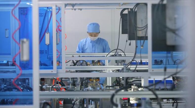 A worker works on the production line of SARS-COV-2 testing kits in a biopharmaceutical company in Nantong city in east China's Jiangsu province Monday, March 9, 2020.