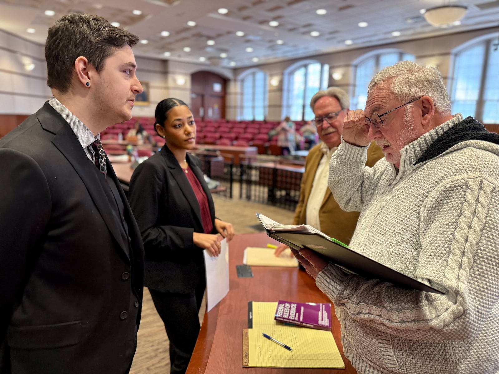 Law school student prosecutors Nate Kraft (left) and Arabella Loera, consult with opposing counsel Dennis Lieberman (far right) and Jose Lopez who are real life defense attorneys. 
CAROLE JUDGE/CONTRIBUTED