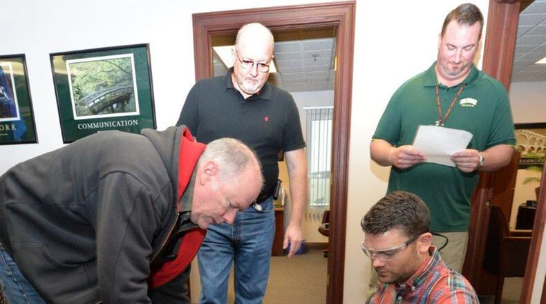 From left, Mark Smith, Eric Pressley and Derek Terrillion, 88th Civil Engineer Squadron Operations Disaster Assessment Team members, run through their checklist while being evaluated by Rick Leach, 88th Air Base Wing inspector general team member, during a simulated tornado touchdown exercise at Wright-Patterson AFB May 4. In an actual event, the DAT would evaluate damaged structure integrity for first responder safety issues. (U.S. Air Force photo/Al Bright)