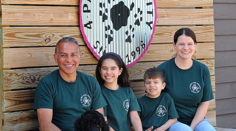 The Tibuni Family, from left, Daniel, Emerson, age 10, Branson, age 6, and Kandice, and sitting in front is 2-year-old Tamera, a standard Poodle. The family all volunteer at 4 Paws For Ability in Xenia. MARSHALL GORBY\STAFF