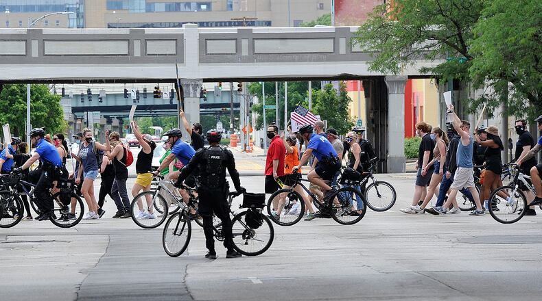 Dayton police help block traffic for protesters during a march for George Floyd on Saturday, June 6, 2020, in Dayton. MARSHALL GORBY/STAFF