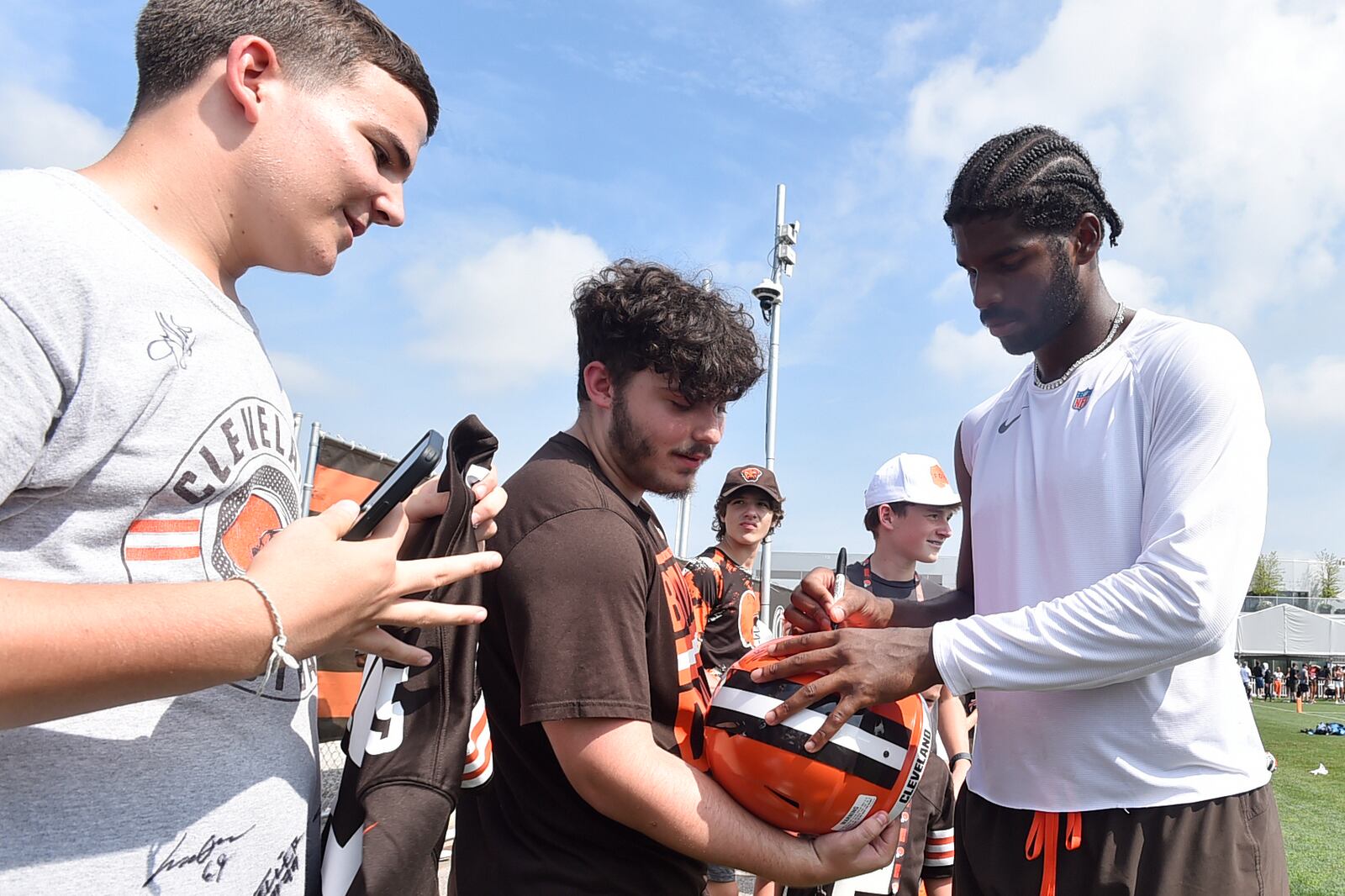 Cleveland Browns quarterback Shedeur Sanders, right, signs autographs after a practice at the team's NFL football training camp Saturday, July 26, 2025, in Berea, Ohio. (AP Photo/David Richard)