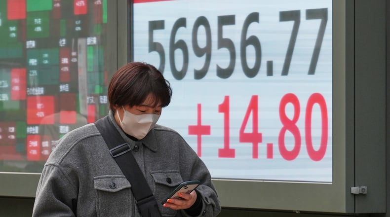 A person walks in front of an electronic stock board showing Japan's Nikkei index at a securities firm Monday, Feb. 16, 2026, in Tokyo. (AP Photo/Eugene Hoshiko)