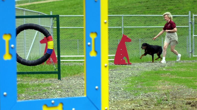Nancy Ellis takes her Rottweiler Gracie through an obstacle course on the grounds of Montgomery County's Bark Park. STAFF FILE PHOTO