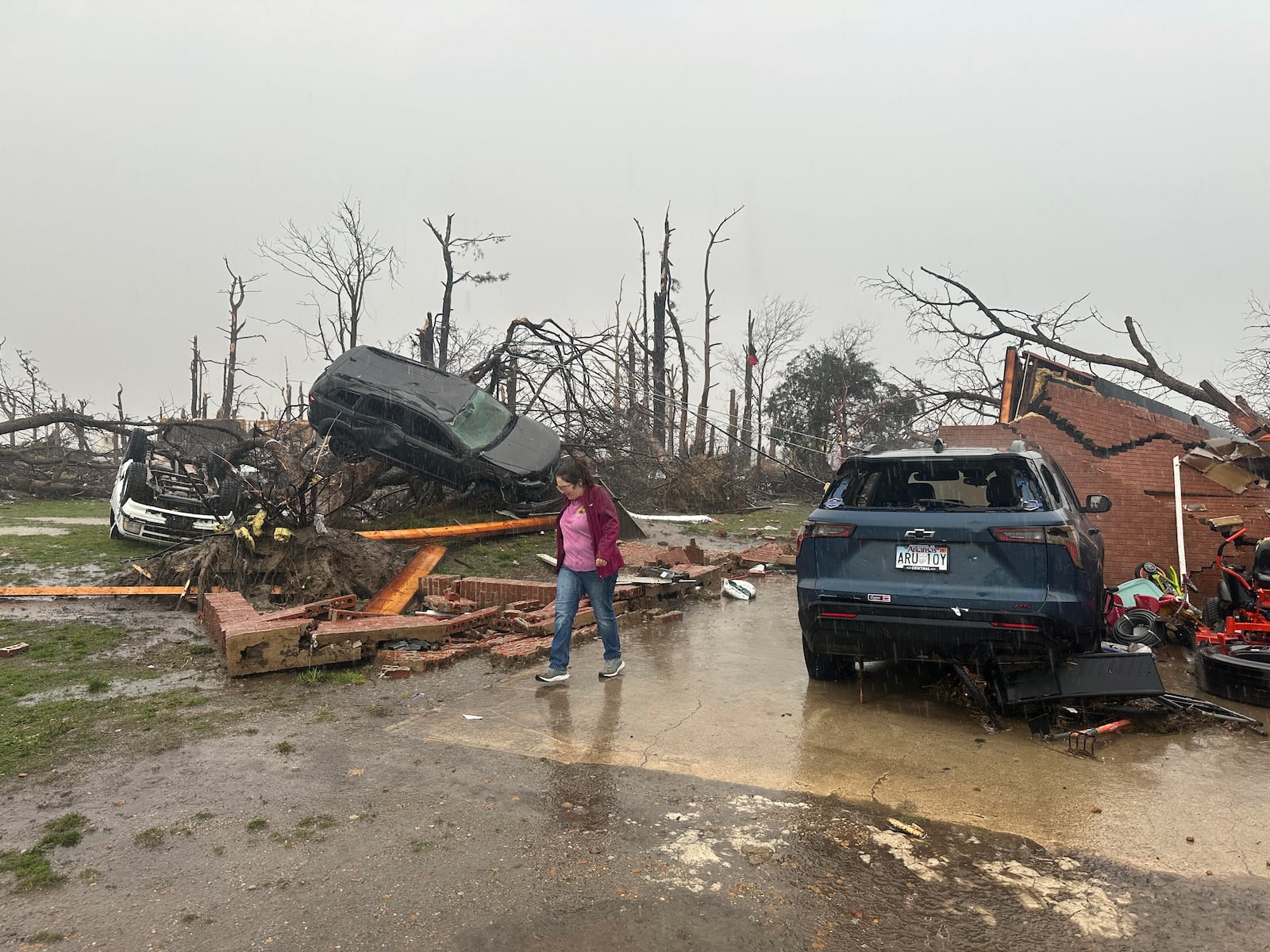 People look over the debris around a home at Lake City, Ark., on Thursday, April 3, 2025. (AP Photo/Adrian Sainz)