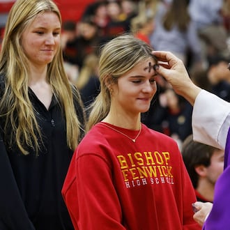 Madyson Schuh, left, receives ashes from Father Steve Pawelk with Glenmary Home Missioners during Bishop Fenwick High School's Ash Wednesday mass in the gymnasium Wednesday. Feb. 14, 2024. NICK GRAHAM/STAFF
