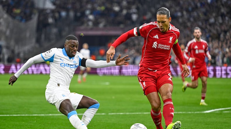 Liverpool's Virgil van Dijk kicks the ball ahead of Marseille's Timothy Weah, left, during the Champions League opening phase soccer match between Marseille and Liverpool in Marseille, France, Wednesday, Jan. 21, 2026. (AP Photo/Philippe Magoni)
