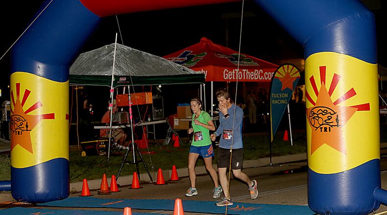 Kelsey Kennedy, from Edgewood, Ky., and Trent Turner, from Butler, Ky., complete the Midnight Madness Half Marathon last year in Hamilton. This year’s NightGlow Marathon will take place Sept. 2.
