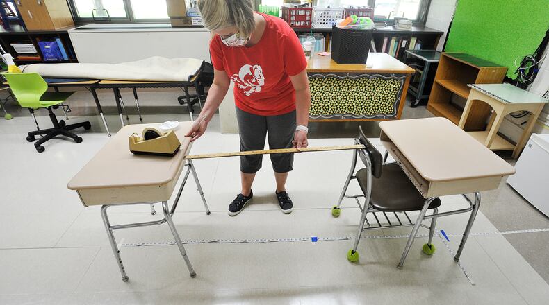 Orchard Park Elementary, Second grade teacher, Kristie Schuller, uses a yardstick and a tape measure to help with social distancing of desk for her class to start the new year. MARSHALL GORBY\STAFF