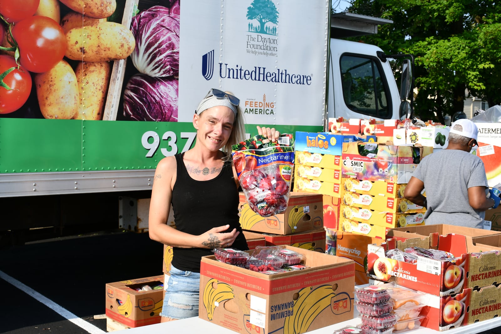 Foodbank employee Carolyn Rife holds up produce at a mobile pantry distribution. CONTRIBUTED
