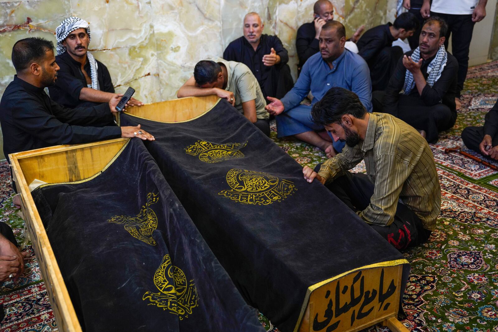Mourners attend the funeral of victims who died in a fire at a shopping center in Kut, at the shrine of Imam Ali in Najaf, Iraq, Thursday, July 17, 2025. (AP Photo/Anmar Khalil)