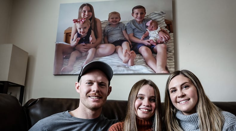 Dylan, left and Kristen White, right, are hoping for a service dog for their daughter Emma who suffered life threatening injuries in an auto accident on Interstate 675 in 2021. The White family also lost Emma's infant sister in the crash. JIM NOELKER/STAFF