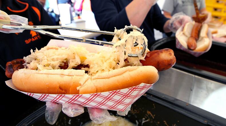 A giant hot dog is topped with sauerkraut at the Hawg Dawgs booth, supporting the Waynesville High School’s athletic boosters, during Saturday’s Sauerkraut Festival in Waynesville, Ohio, Oct. 12, 2013. NICK DAGGY / STAFF
