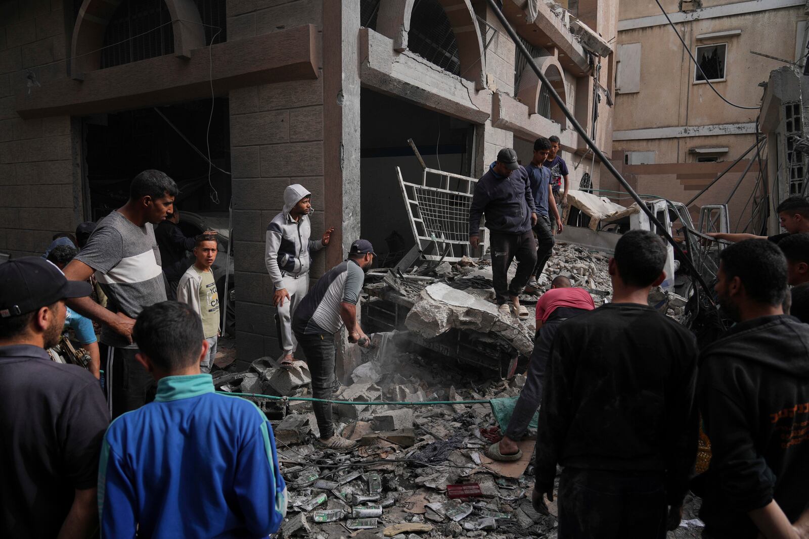 Palestinians inspect the damage caused by an Israeli army airstrike in Khan Younis, Gaza Strip, Tuesday, April 22, 2025. (AP Photo/Abdel Kareem Hana)