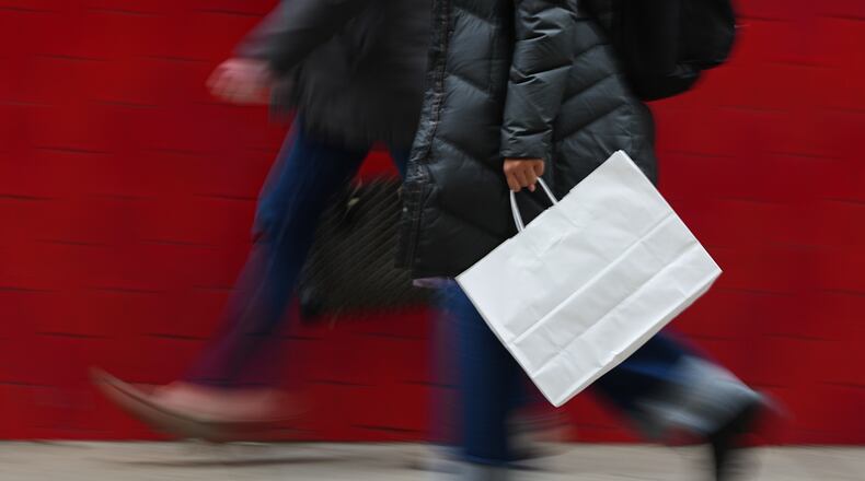 FILE - A person carries a shopping bag in Philadelphia, Wednesday, Dec. 10, 2025. (AP Photo/Matt Rourke, File)