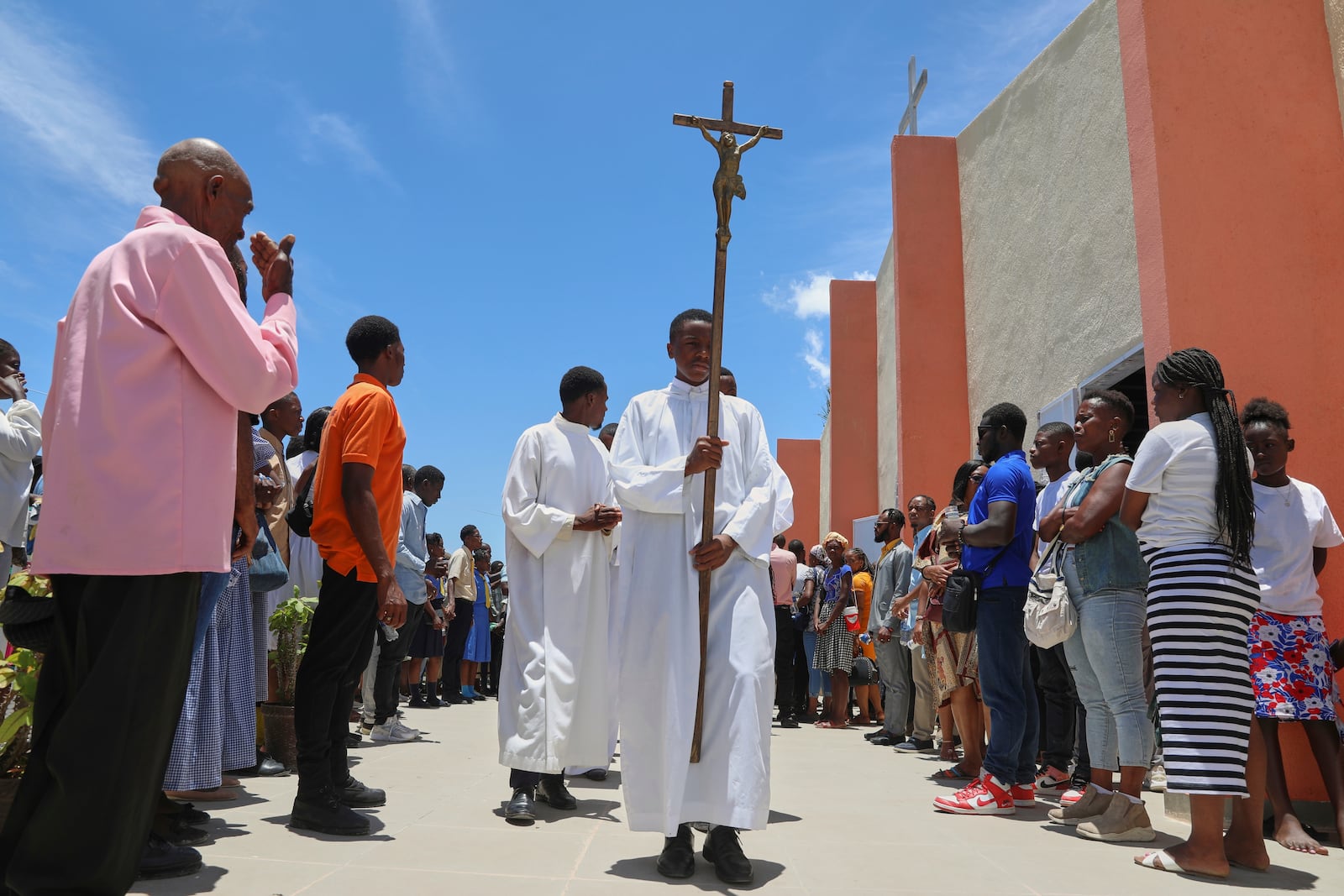 A cross-bearer leads a liturgical procession at the end of a Mass marking the Feast of Our Lady of Mount Carmel at the namesake church in the Pétion-Ville neighborhood of Port-au-Prince, Haiti, on Wednesday, July 16, 2025. (AP Photo/Odelyn Joseph)