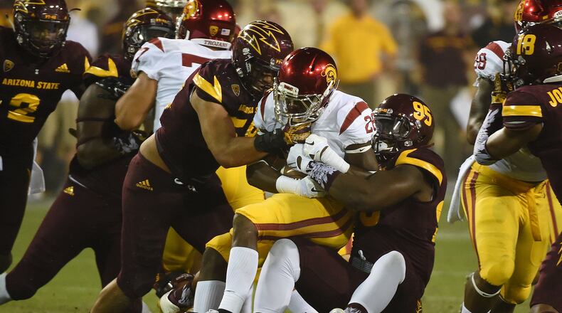 TEMPE, AZ - SEPTEMBER 26: Aca’Cedric Ware #28 of the Southern California Trojans is tackled by Salamo Fiso #58 and Renell Wren #95 of the Arizona State University Sun Devils during the second half at Sun Devil Stadium on September 26, 2015 in Tempe, Arizona. Trojans won 42-14. (Photo by Norm Hall/Getty Images)