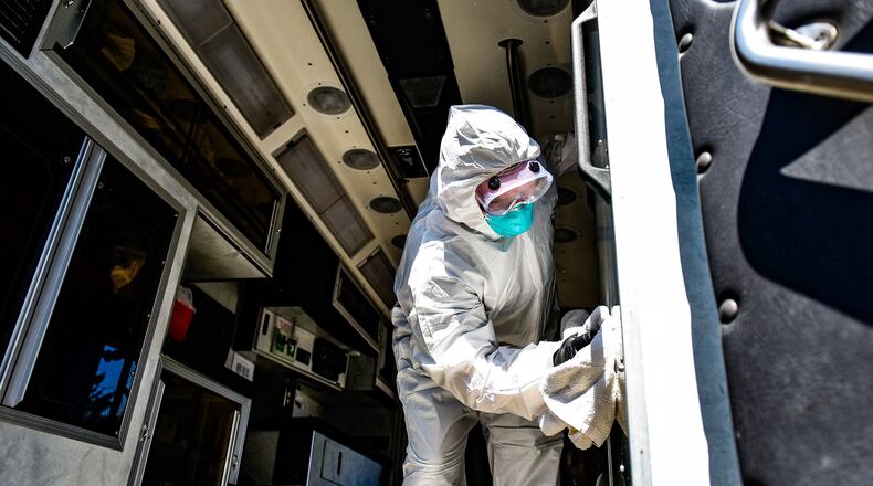 A firefighter-paramedic puts on protective gear to demonstrate the decontamination process to medic units in response to the coronavirus (COVID-19) pandemic. NICK GRAHAM / STAFF