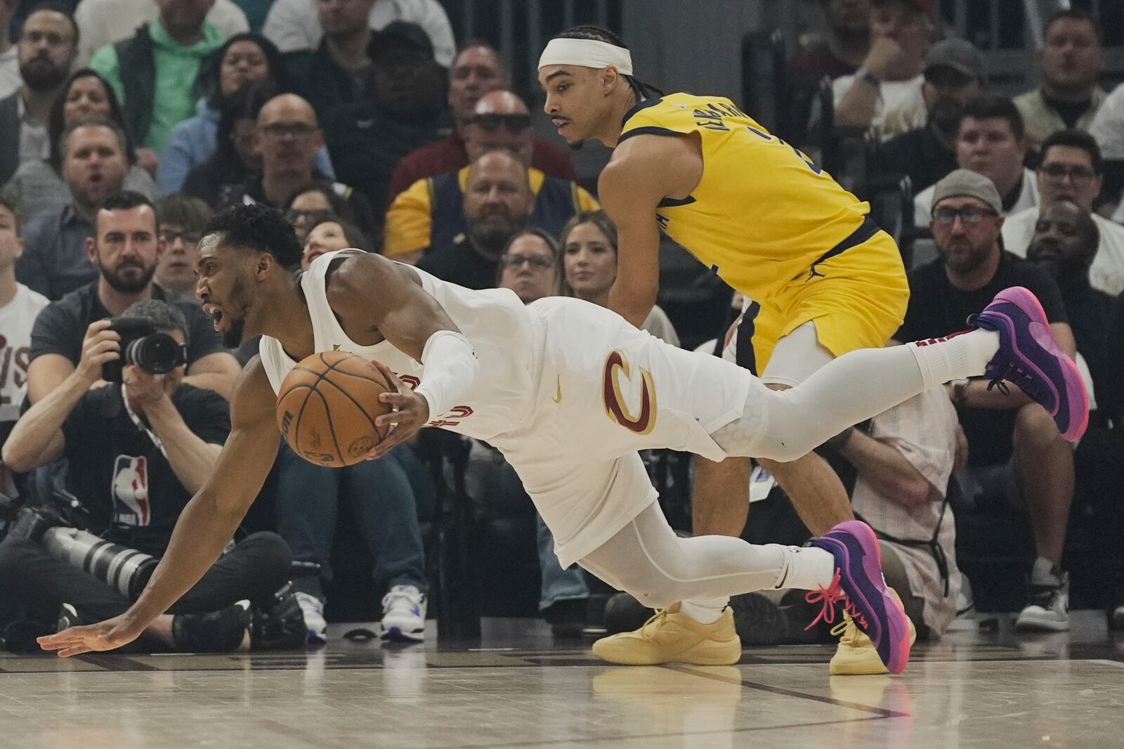 Cleveland Cavaliers guard Donovan Mitchell, left, falls after being fouled by Indiana Pacers guard Andrew Nembhard, right, in the first half during Game 2 in the Eastern Conference semifinals of the NBA basketball playoffs Tuesday, May 6, 2025, in Cleveland. (AP Photo/Sue Ogrocki)
